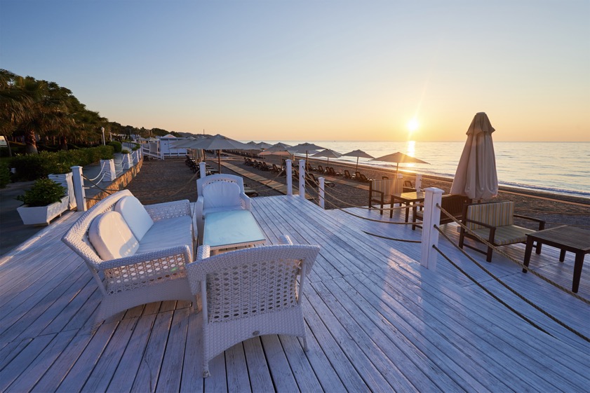 Scenic view of sandy beach on the beach with sun beds and umbrellas open against the sea and mountains. Hotel. Resort. Tekirova-Kemer. Turkey